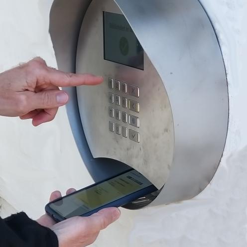 Stregkode på mobil holdes under skanner mens kode tastes